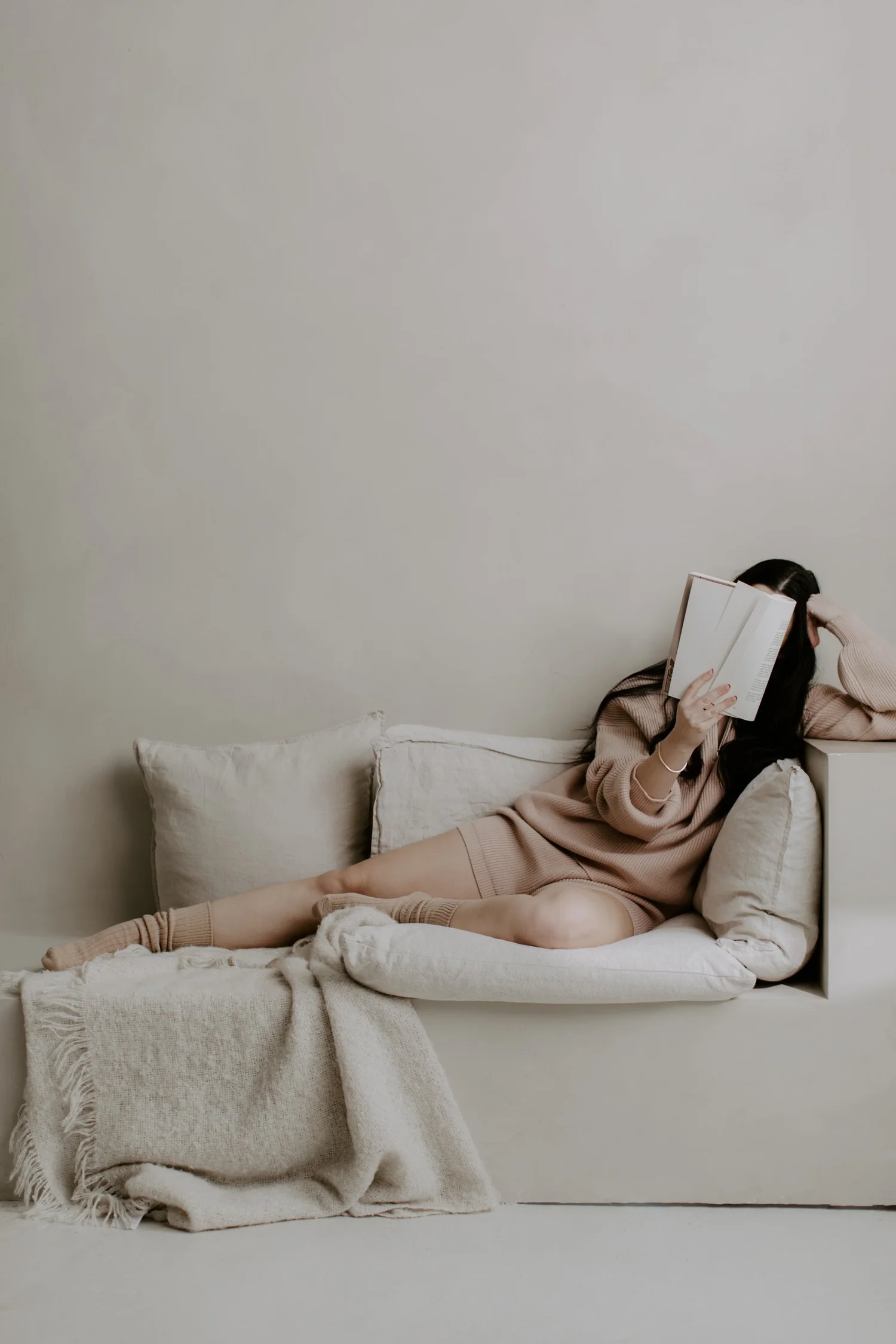 Woman resting with a book in a calm, light-filled room